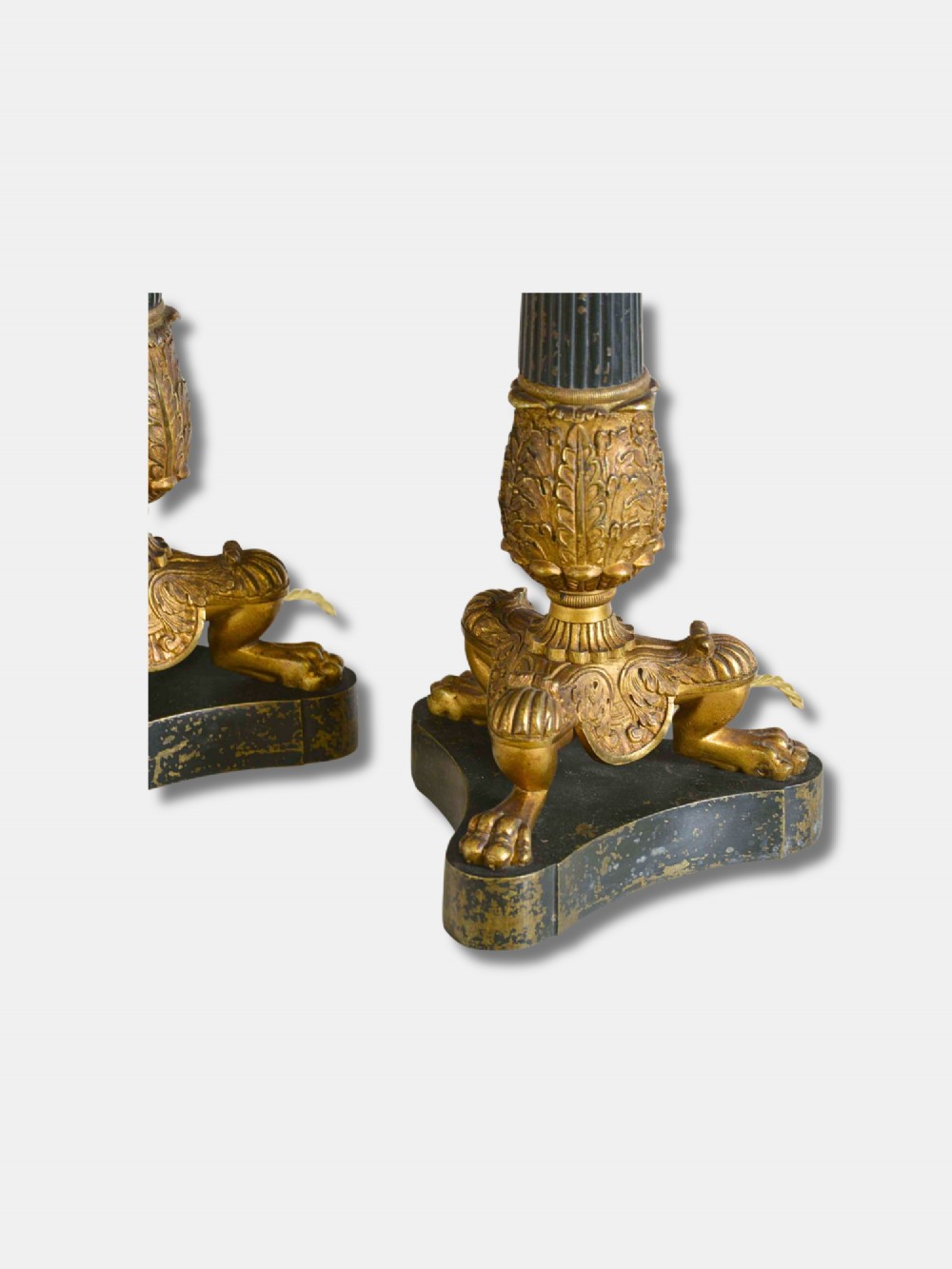 A pair of French Empire table lamps featuring dark fluted column shafts, gilded leaf capitals, lion paw feet, and triangular bases. View II