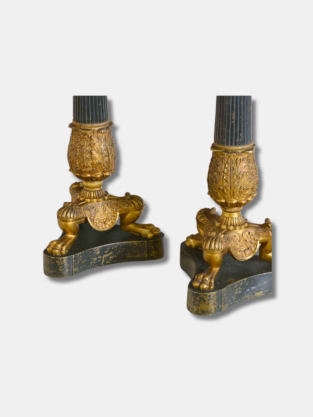 A pair of French Empire table lamps featuring dark fluted column shafts, gilded leaf capitals, lion paw feet, and triangular bases. View III