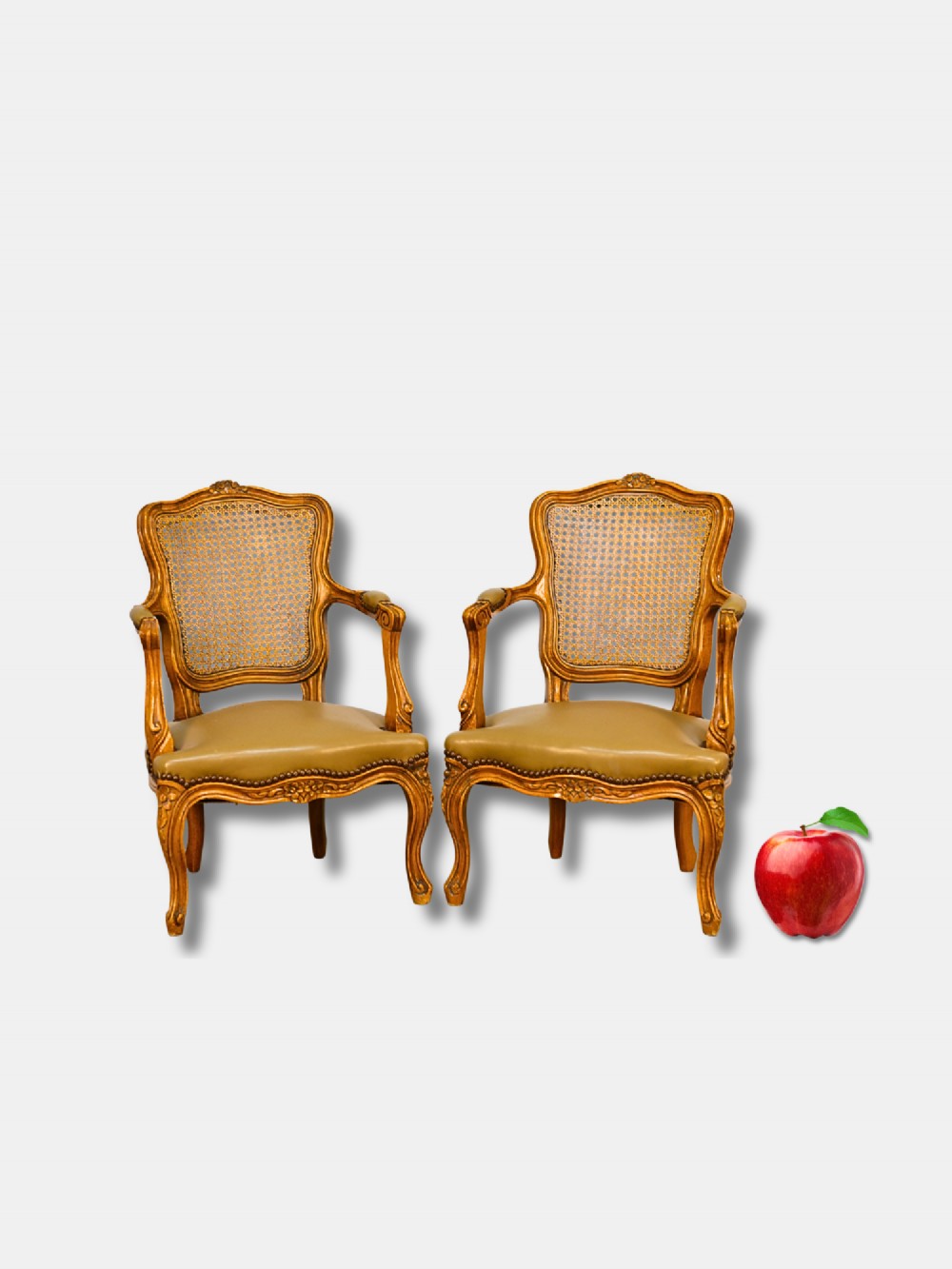 A pair of 19th-century French child-sized walnut armchairs featuring carved frames, woven cane backrests, cabriole legs, and olive green leather seats.