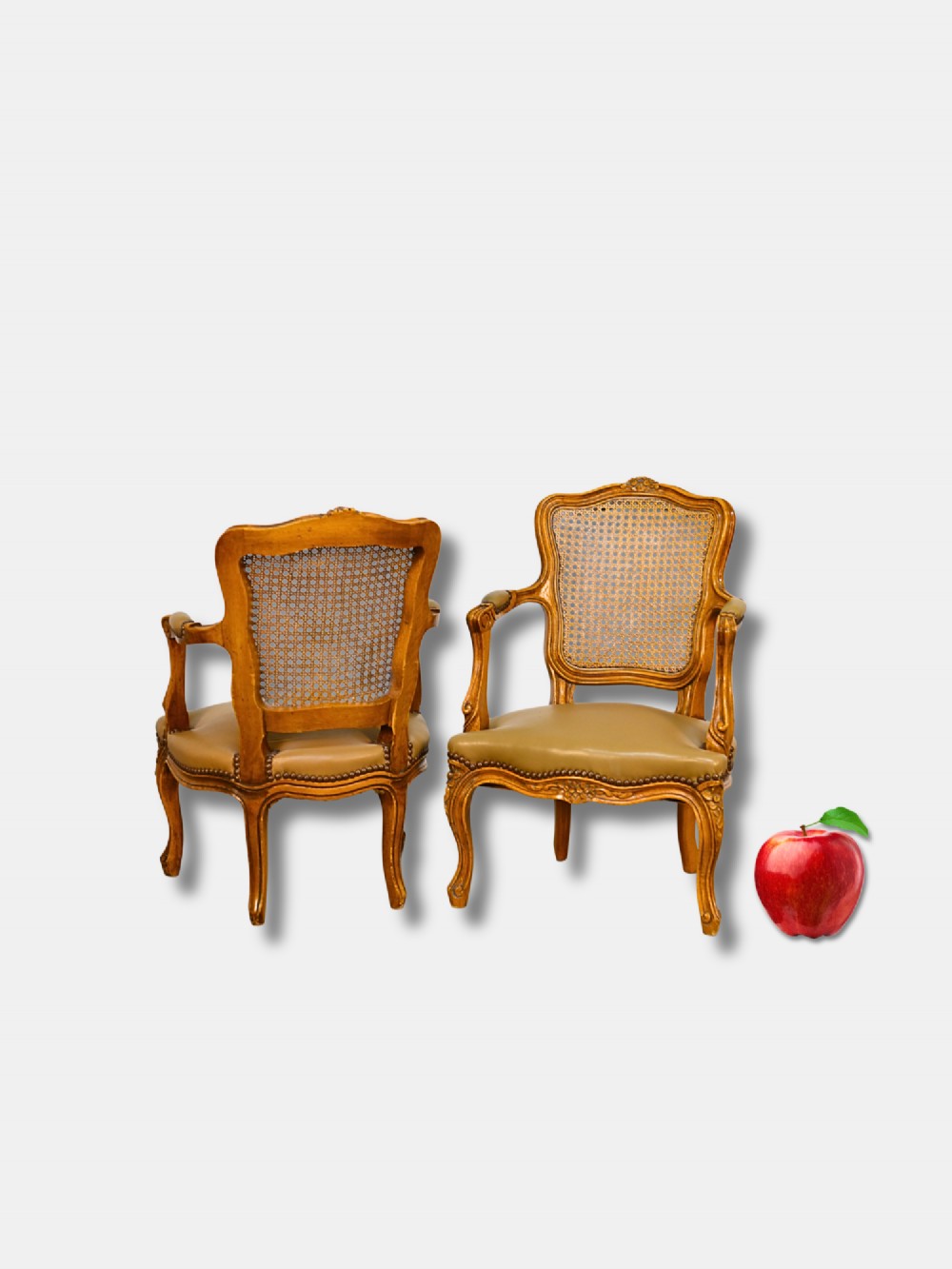 A pair of 19th-century French child-sized walnut armchairs featuring carved frames, woven cane backrests, cabriole legs, and olive green leather seats. View II