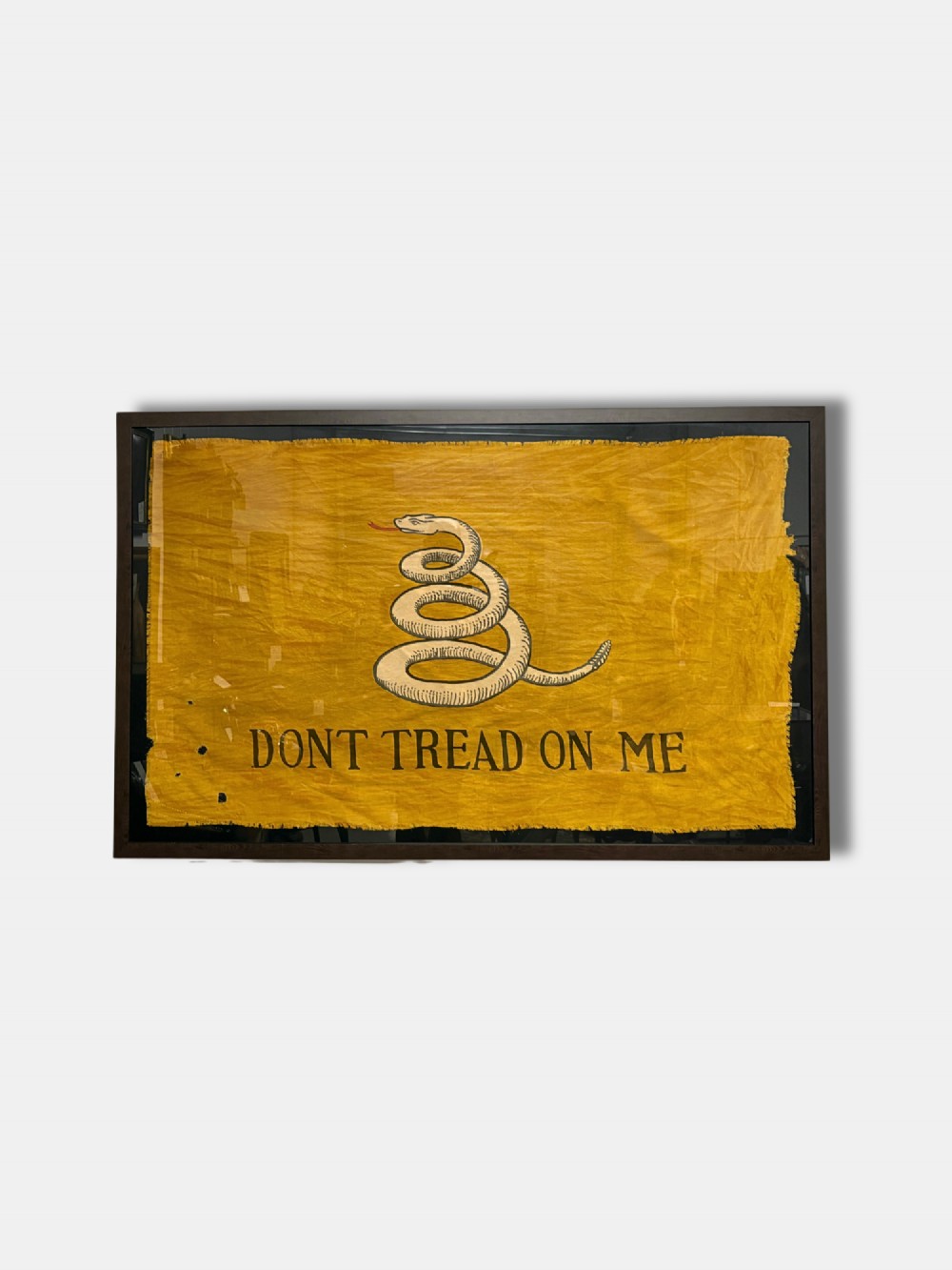 A framed yellow antique Gadsden flag displaying a coiled rattlesnake motif above black lettering reading DONT TREAD ON ME. View II