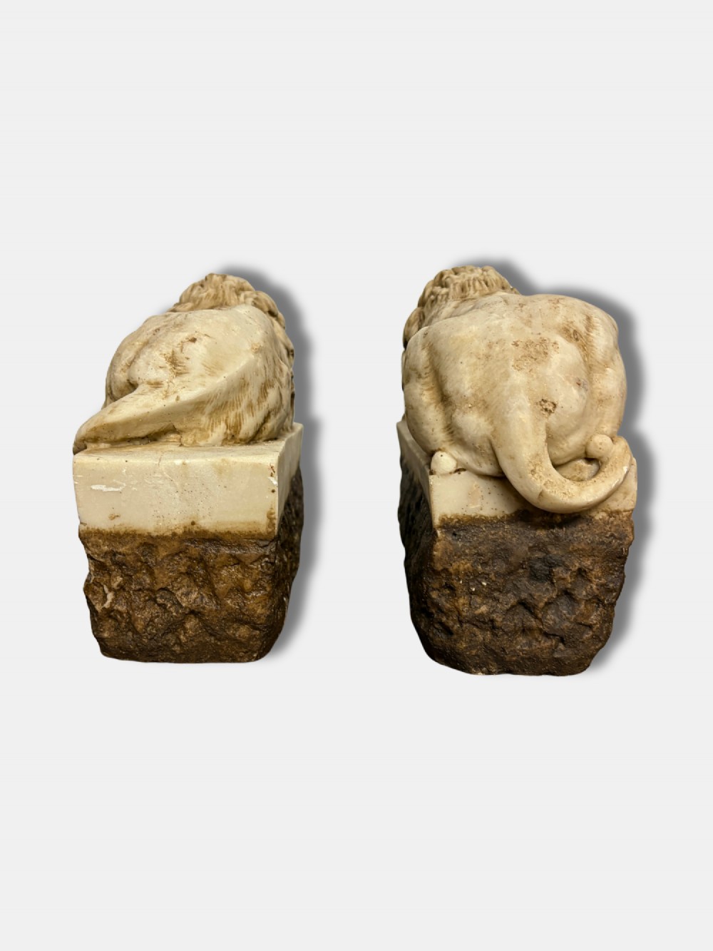 A pair of late nineteenth-century carved alabaster lion sculptures depicted resting atop rustic stone bases, after Antonio Canova. View II