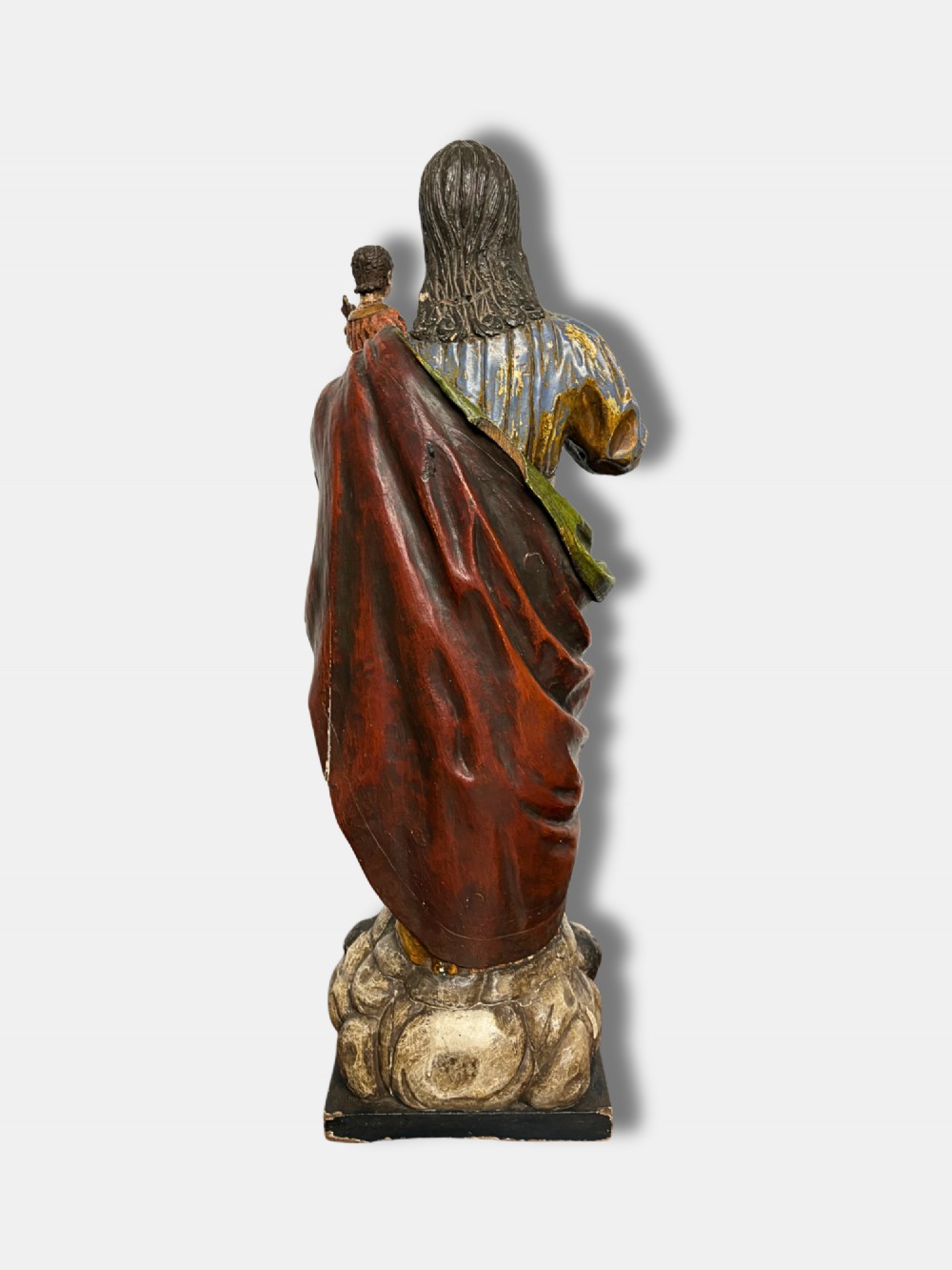 An 18th-century Peruvian carved polychrome wood statue of Saint Joseph holding the infant Jesus standing on a base decorated with cherub heads. View III