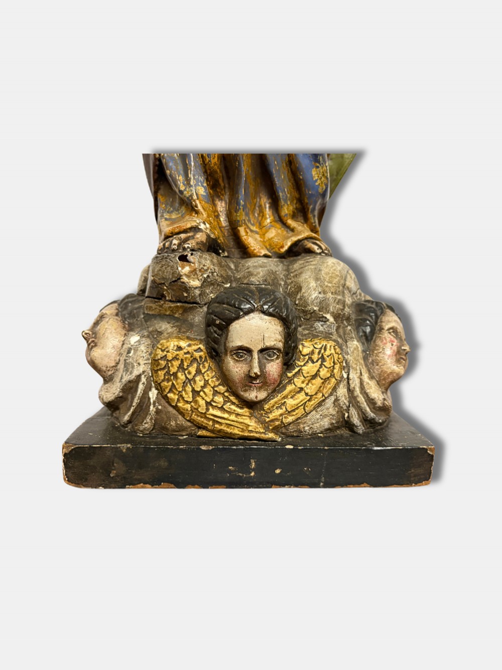 An 18th-century Peruvian carved polychrome wood statue of Saint Joseph holding the infant Jesus standing on a base decorated with cherub heads. View V