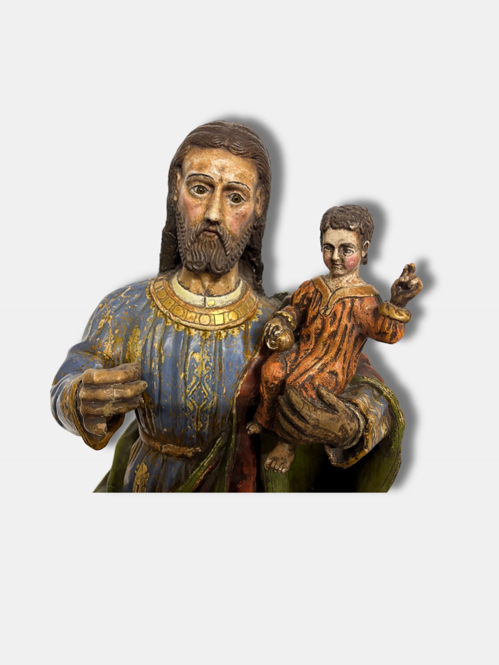 An 18th-century Peruvian carved polychrome wood statue of Saint Joseph holding the infant Jesus standing on a base decorated with cherub heads. View VI