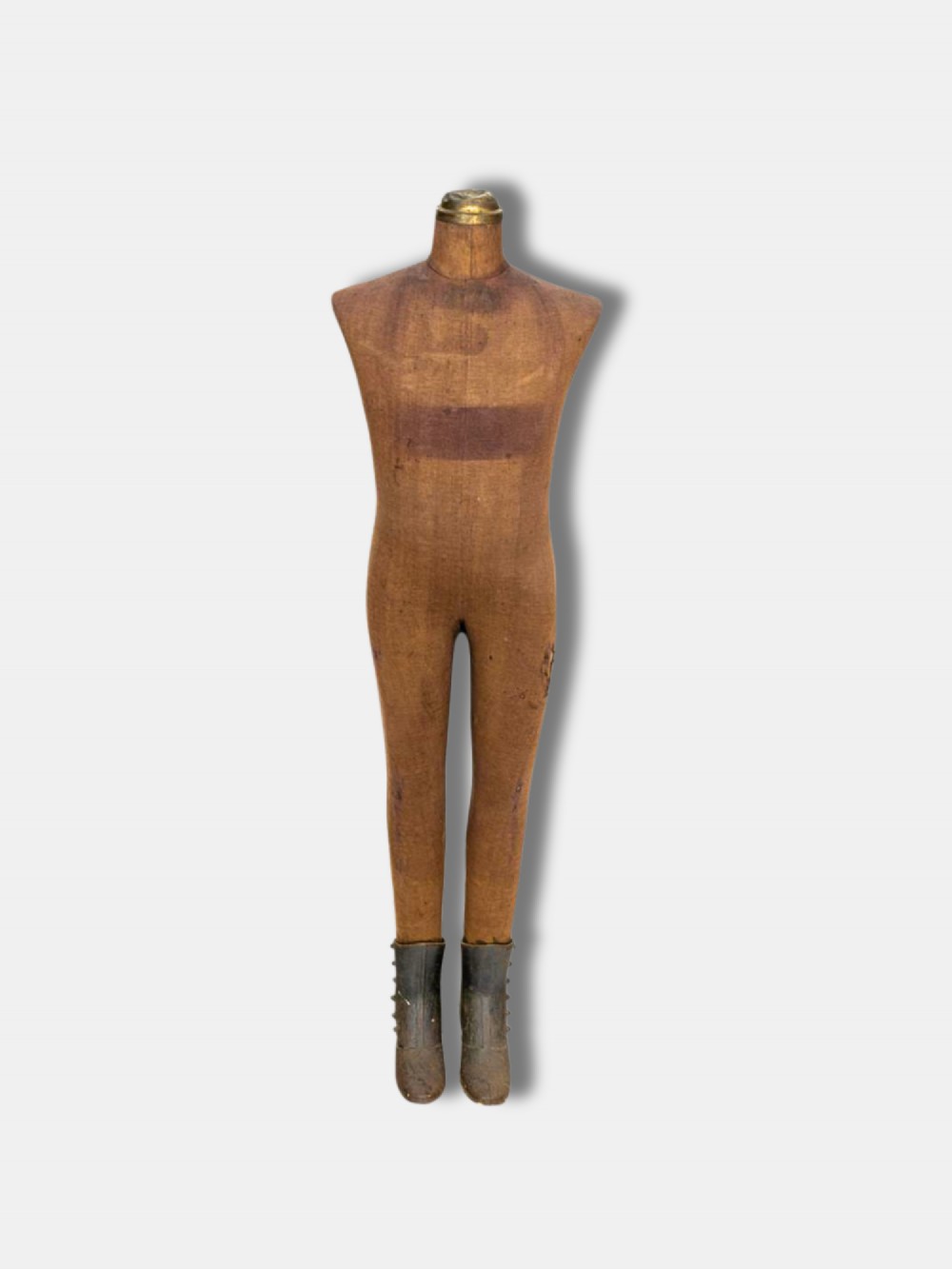 A full-length 19th-century French childs display mannequin upholstered in tan canvas, supported by cast iron boots and topped with a brass neck collar.
