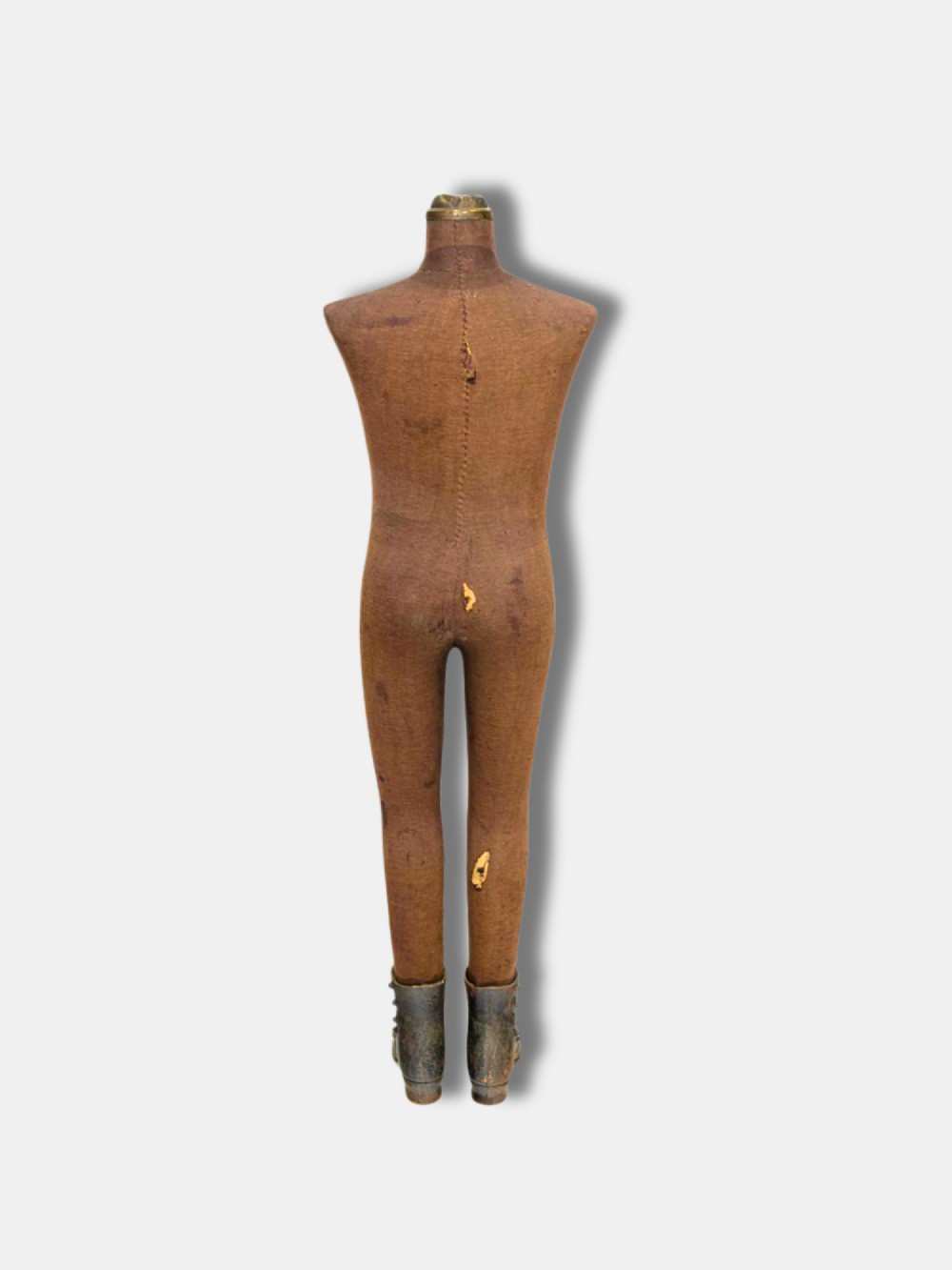 A full-length 19th-century French childs display mannequin upholstered in tan canvas, supported by cast iron boots and topped with a brass neck collar. View II