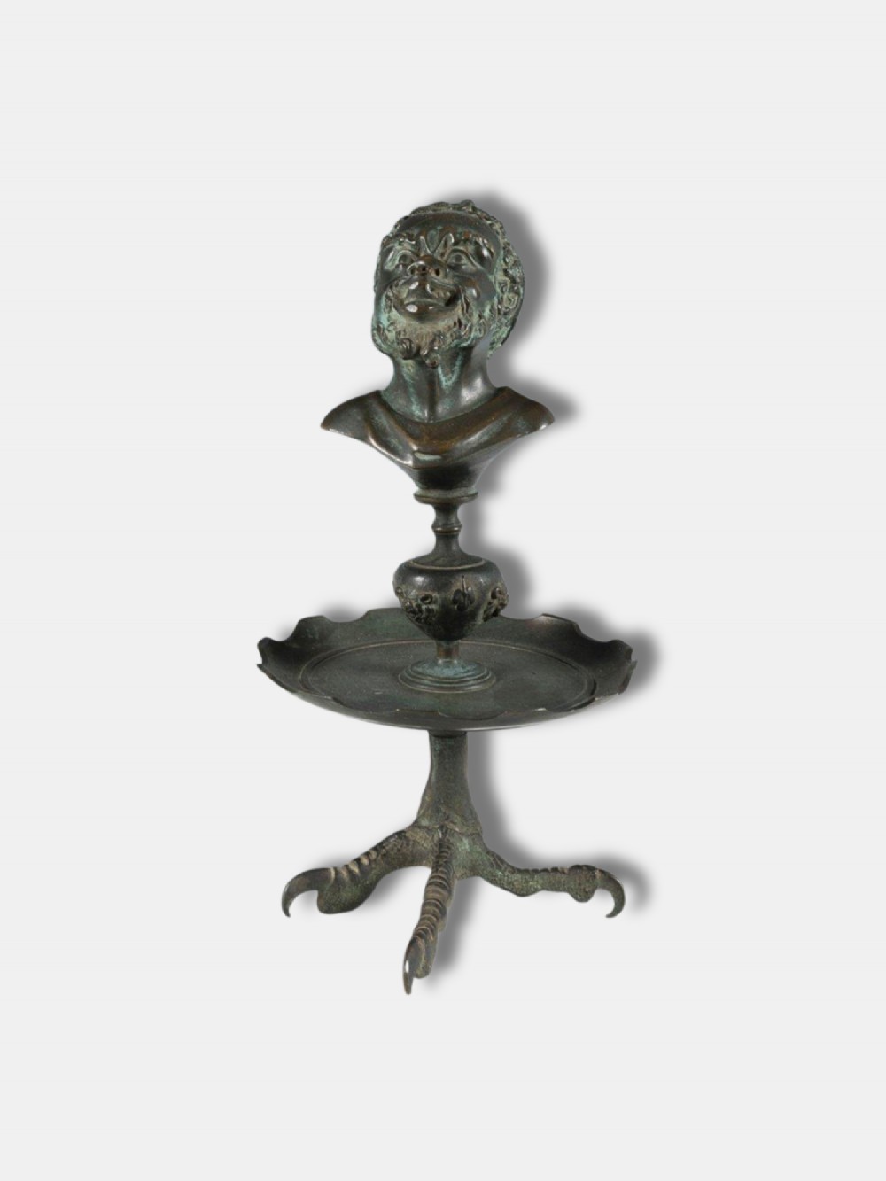 An antique circa 1820 Italian patinated bronze oil lamp featuring a tripod eagle claw base, a central circular tray, and a top finial shaped as a bust of a satyr.