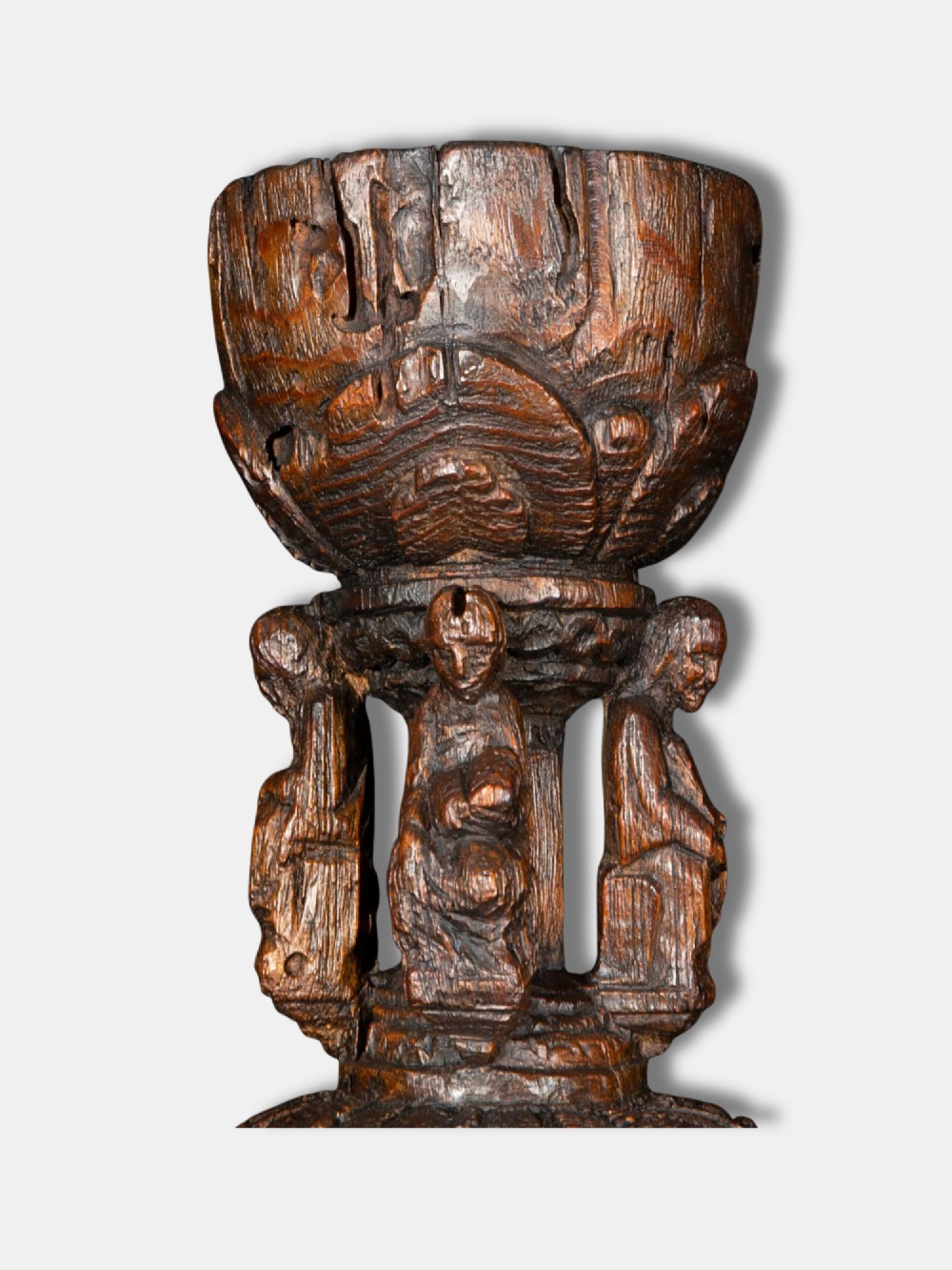 A 16th-century dark carved oak chalice featuring sculpted human figures around the stem and carved leaf motifs on the base and bowl. View III