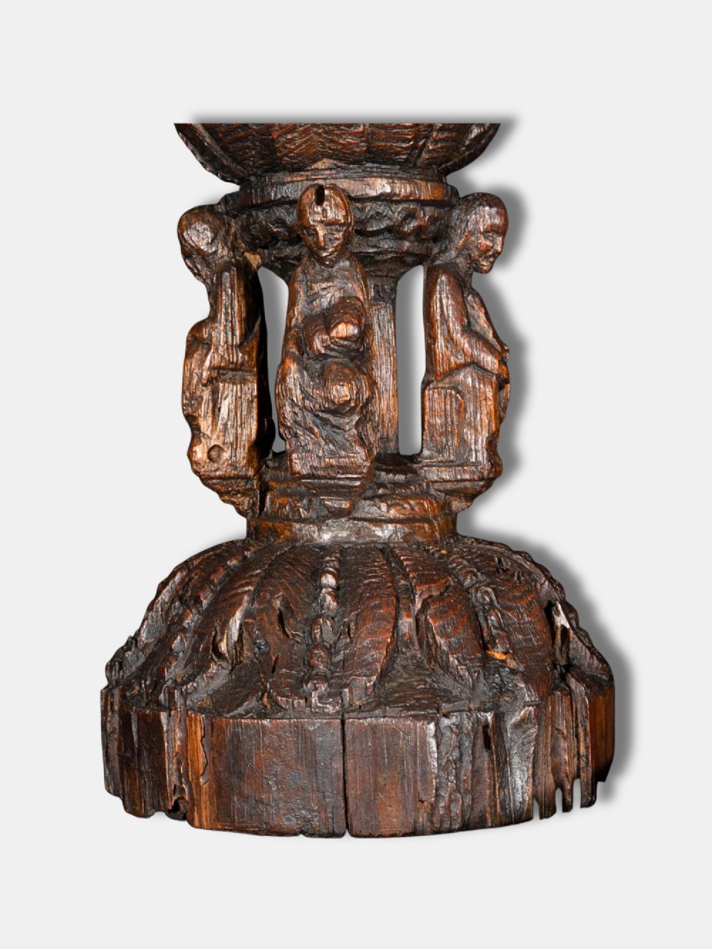 A 16th-century dark carved oak chalice featuring sculpted human figures around the stem and carved leaf motifs on the base and bowl. View IV