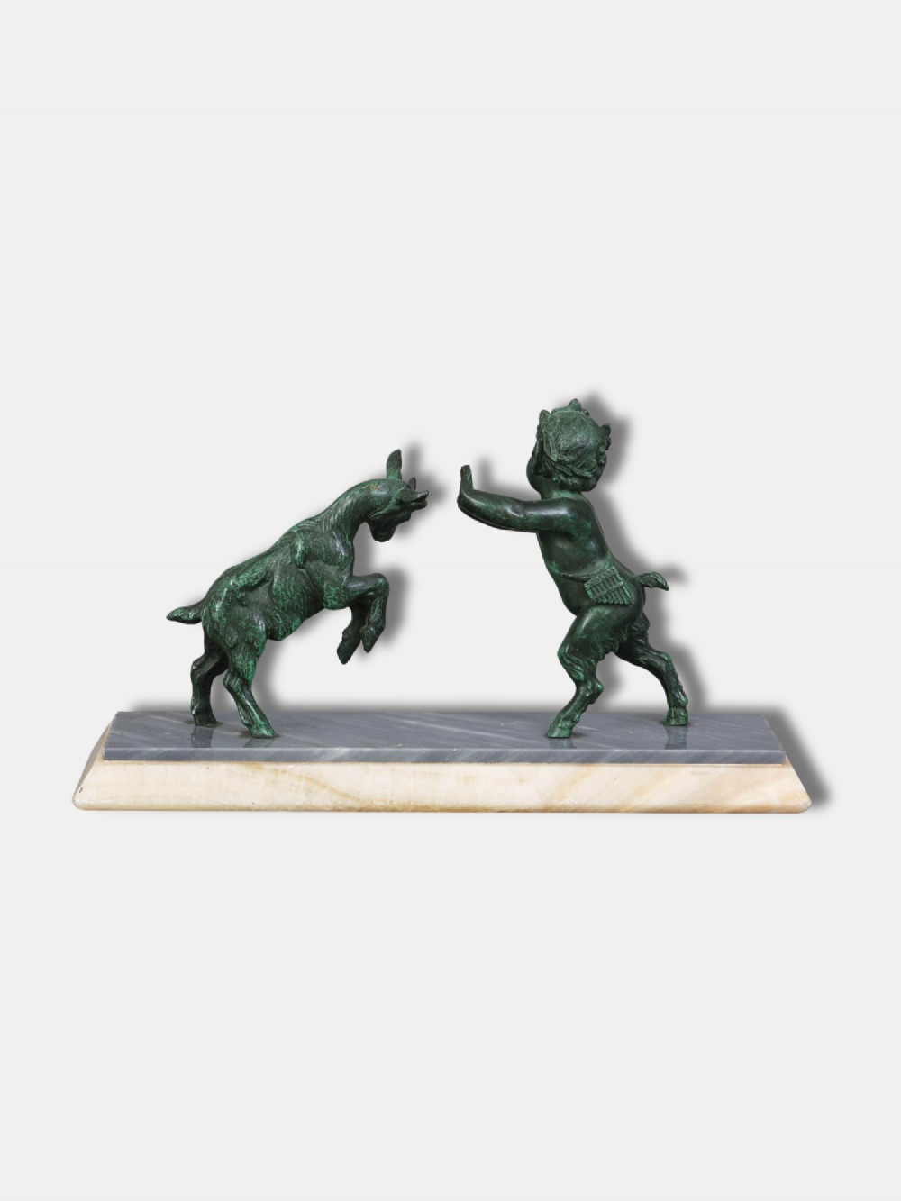 A green patinated bronze sculpture depicting a young faun interacting with a rearing goat, mounted on a rectangular marble base. View II