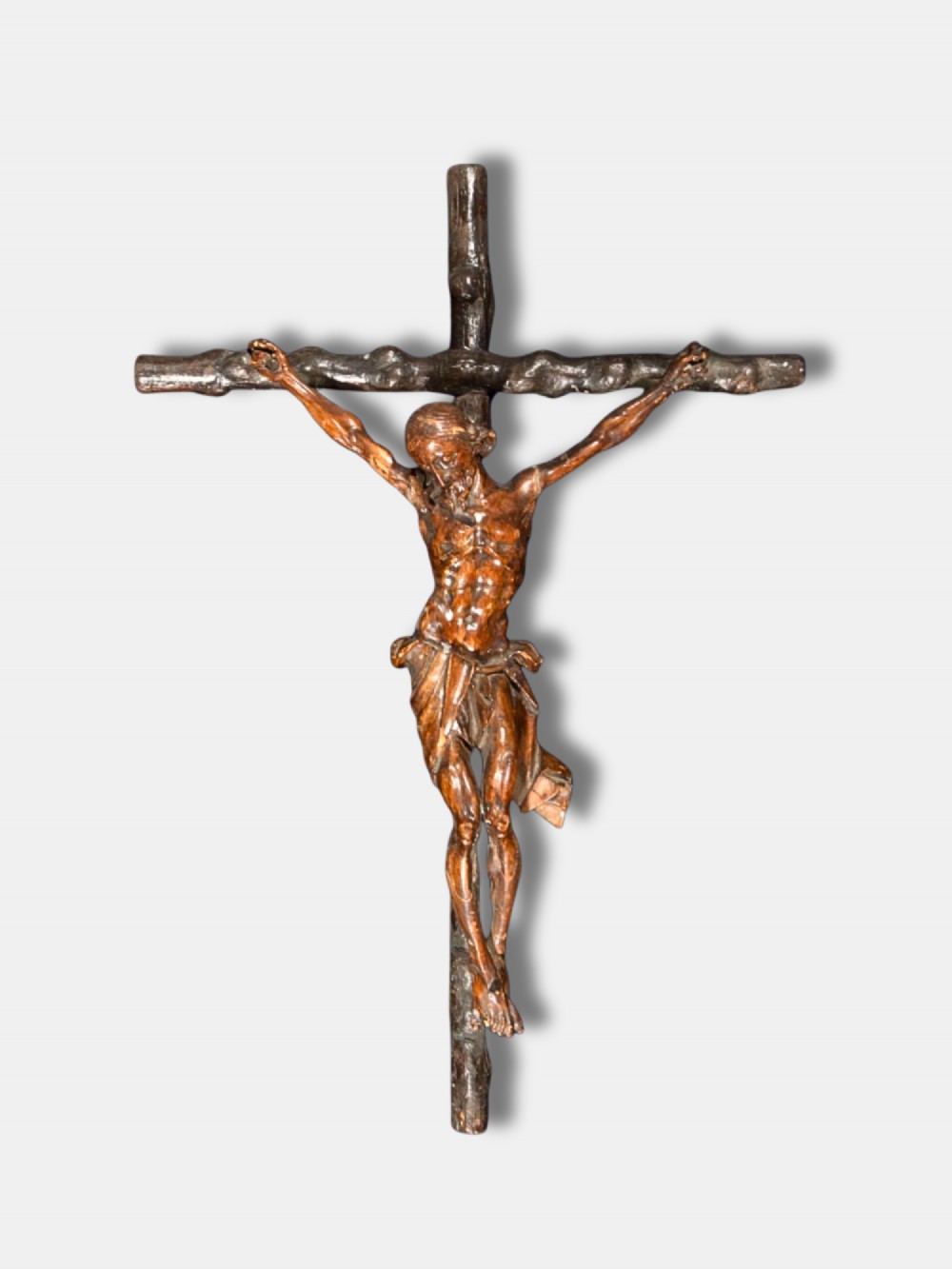 An 18th-century Spanish carved wooden crucifix depicting Jesus Christ on a rustic timber cross.