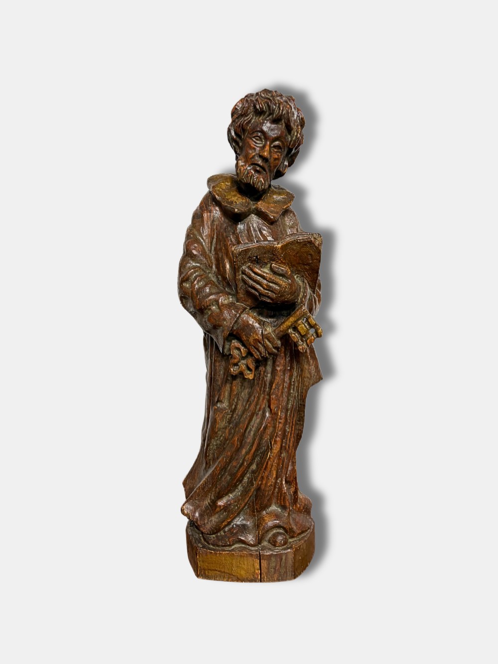 An 18th-century French carved wood statue depicting Saint Peter holding a book and keys.