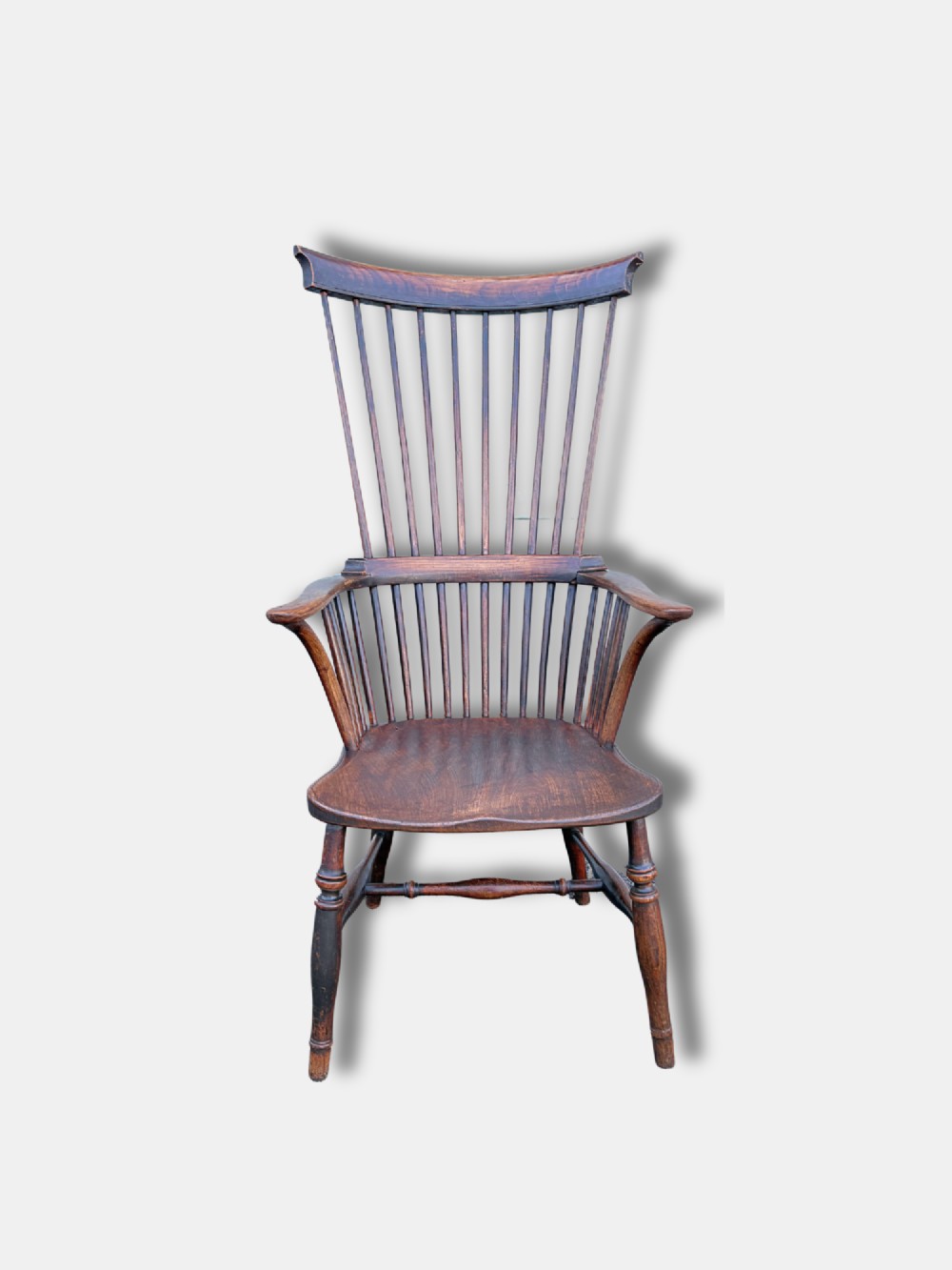 A 19th-century English high comb-back Windsor armchair crafted from dark ash and elm timber with turned spindles and legs. View II