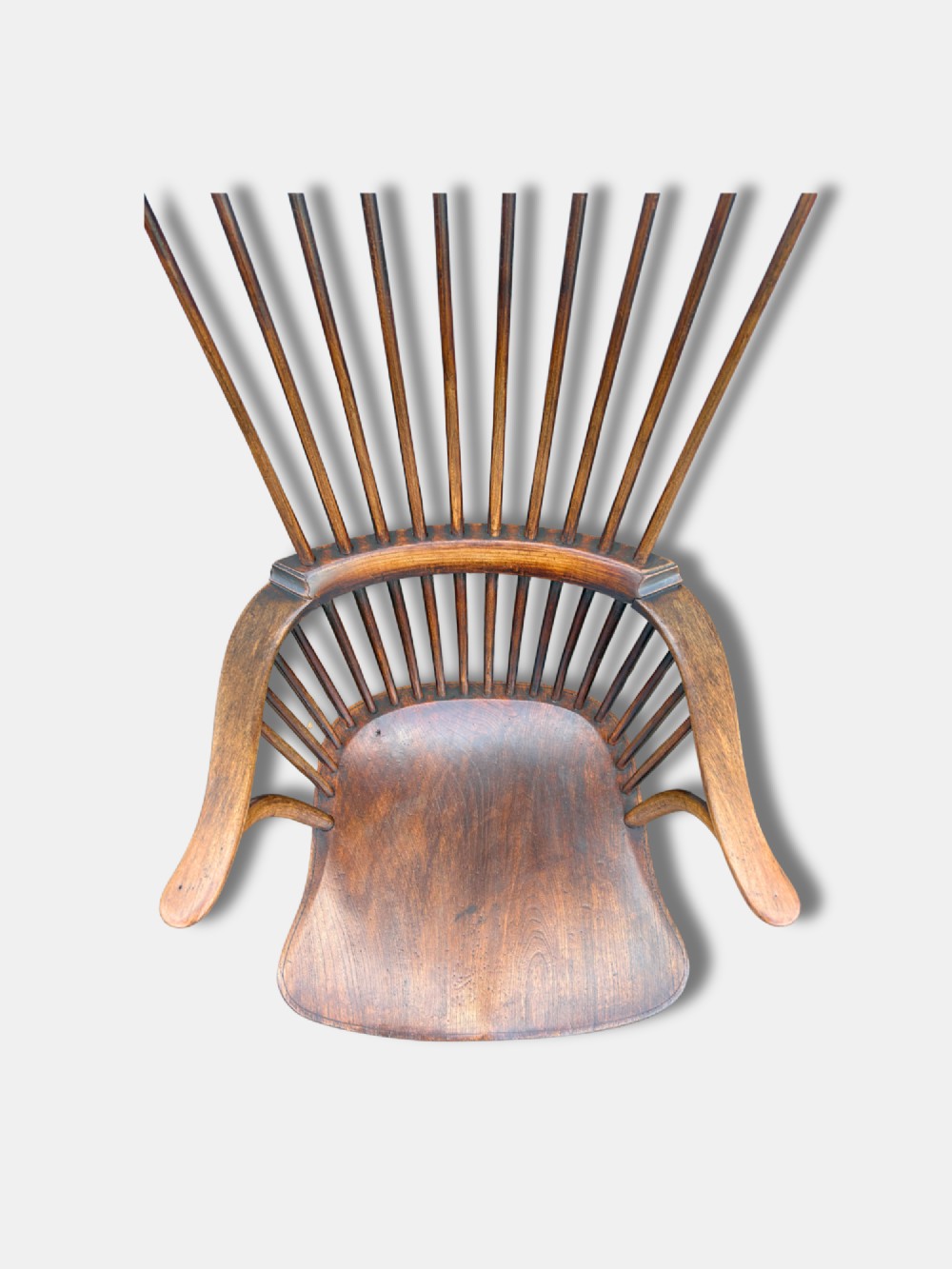 A 19th-century English high comb-back Windsor armchair crafted from dark ash and elm timber with turned spindles and legs. View V