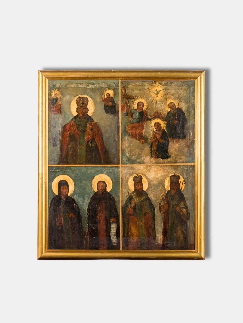 An antique Russian quadripartite icon painting featuring four distinct devotional panels framed in a gilded wood border.