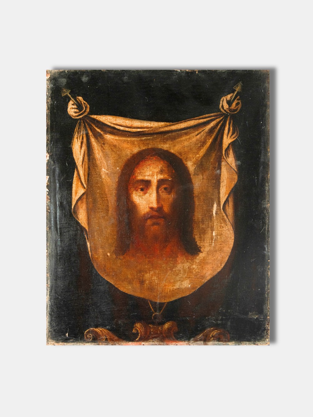 A seventeenth-century Spanish oil painting on canvas depicting the Holy Face of Jesus Christ presented on Veronicas draped veil against a dark ground.