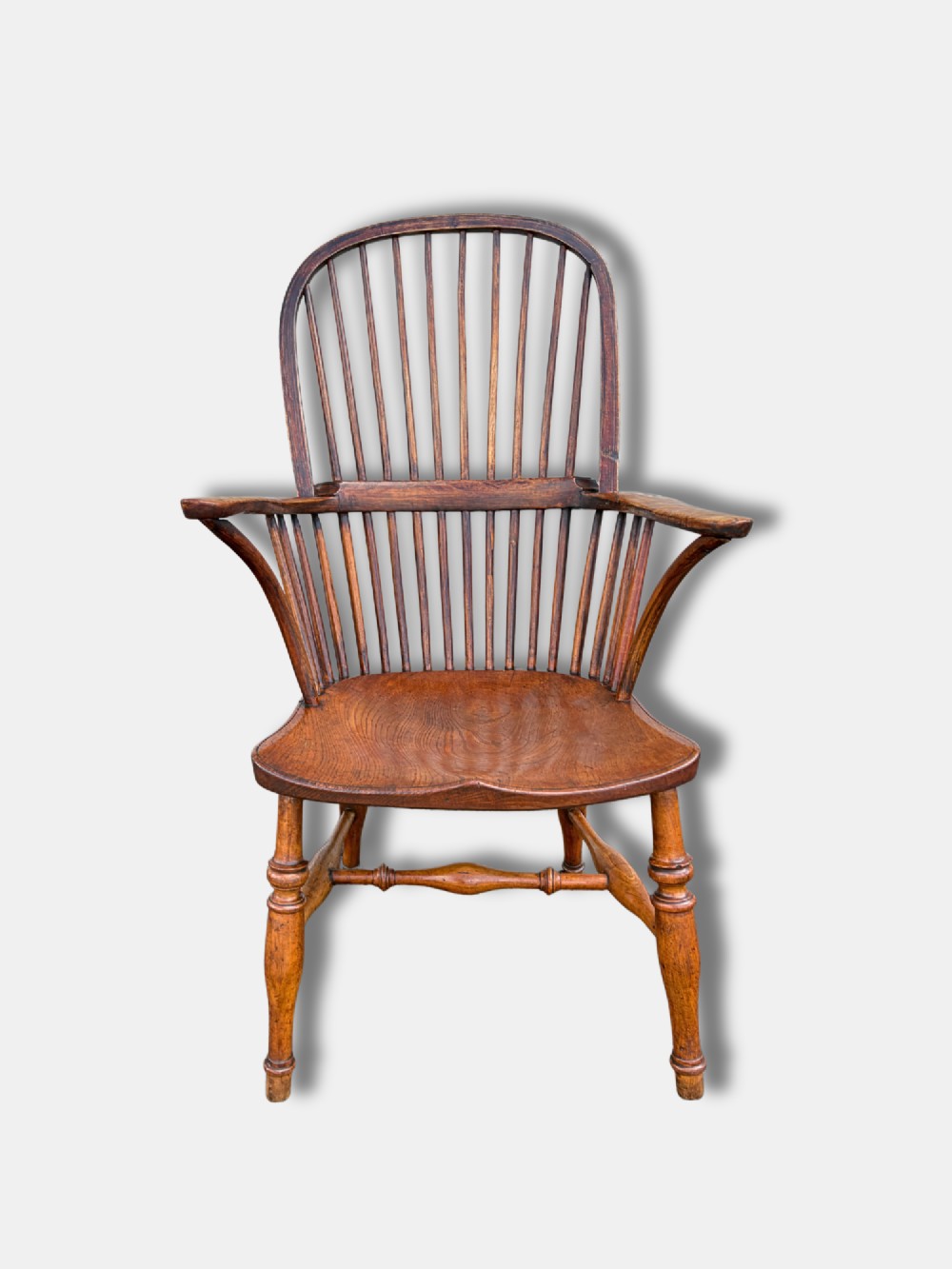 A nineteenth-century English stickback Windsor armchair made of ash and elm with turned legs, an H-stretcher, and a shaped saddle seat. View II