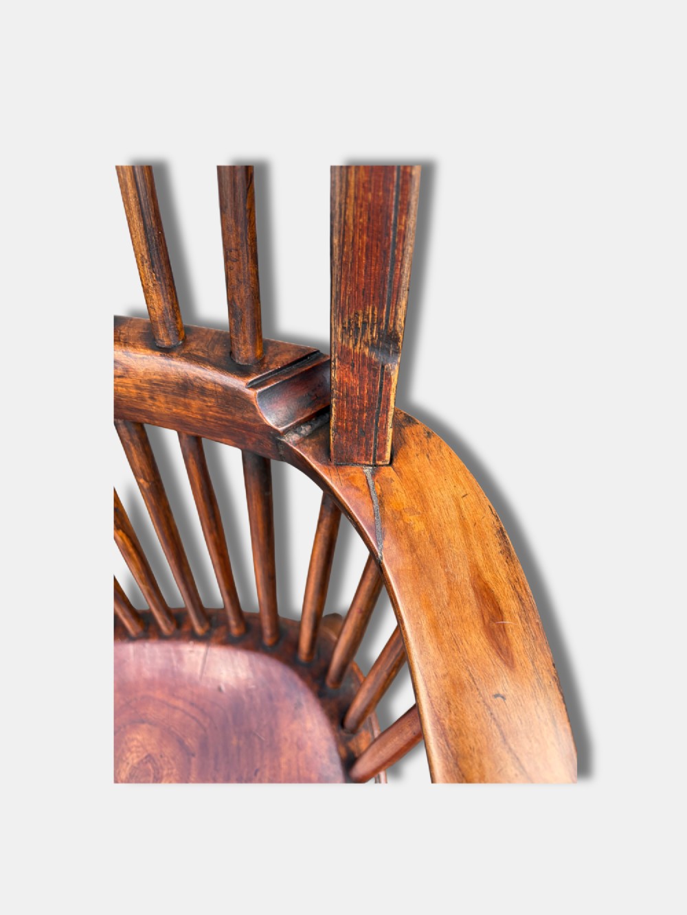 A nineteenth-century English stickback Windsor armchair made of ash and elm with turned legs, an H-stretcher, and a shaped saddle seat. View V