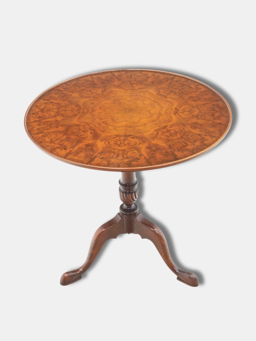 An early 20th-century Georgian style tripod table with a circular burr walnut tilt top raised on a turned column with cabriole legs and pad feet. View II
