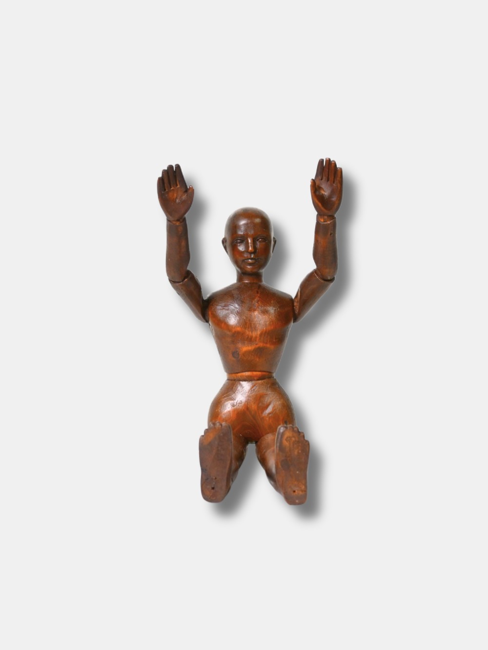 A French carved wood artist lay figure from circa 1890 with fully articulated limbs and a warm brown polished finish shown in a seated posture. View II
