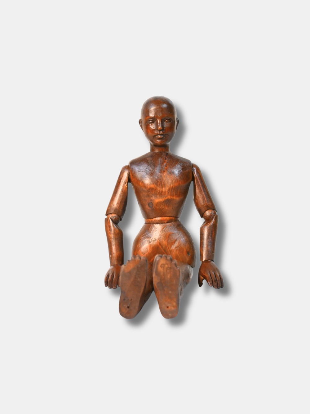 A French carved wood artist lay figure from circa 1890 with fully articulated limbs and a warm brown polished finish shown in a seated posture. View III