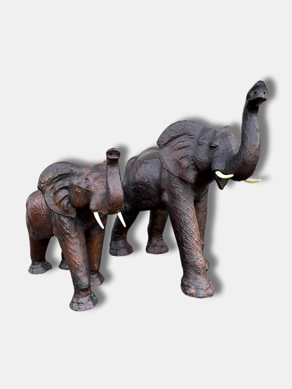 An extra-large antique dark brown leather elephant bench featuring a raised trunk, detailed hide texture, glass eyes, and short tusks. View V