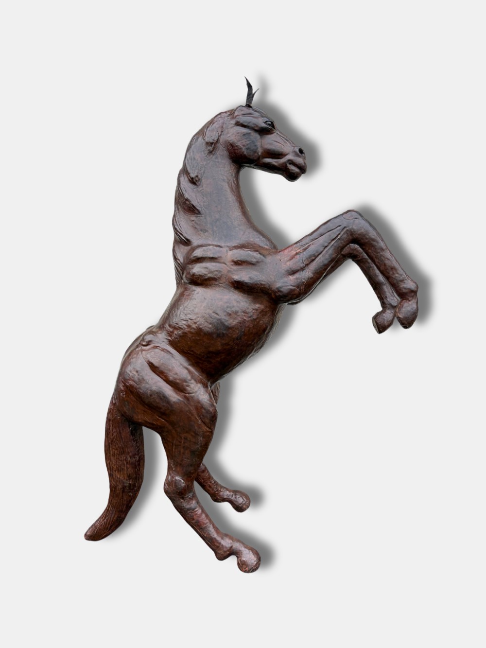 A large dark brown leather rearing horse sculpture crafted with muscular detailing, mane, and tail.