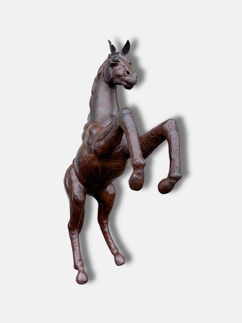 A large dark brown leather rearing horse sculpture crafted with muscular detailing, mane, and tail. View II