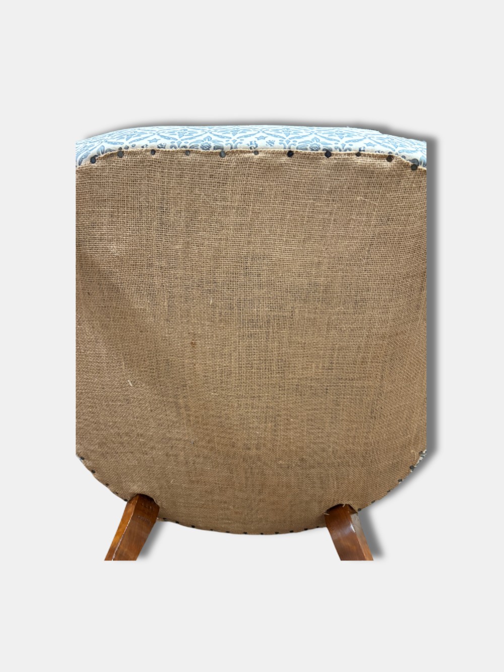 A late Victorian button back armchair upholstered in blue and white botanical patterned fabric, featuring turned wooden front legs on brass castors. View V