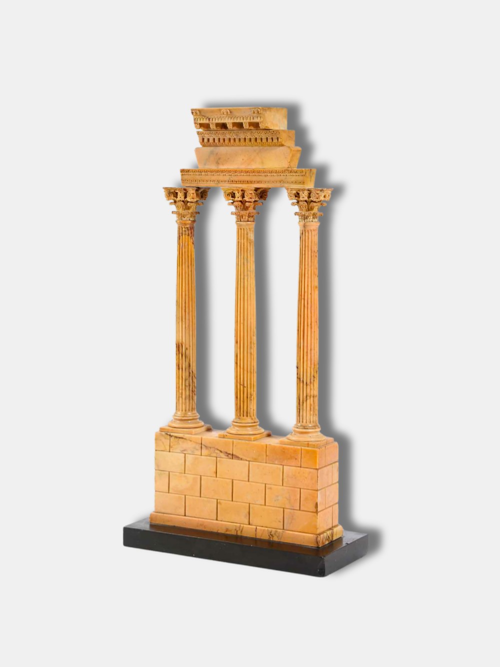 A yellow Giallo Antico marble model depicting three fluted Corinthian columns and entablature from the Temple of Castor and Pollux set on a black marble base.