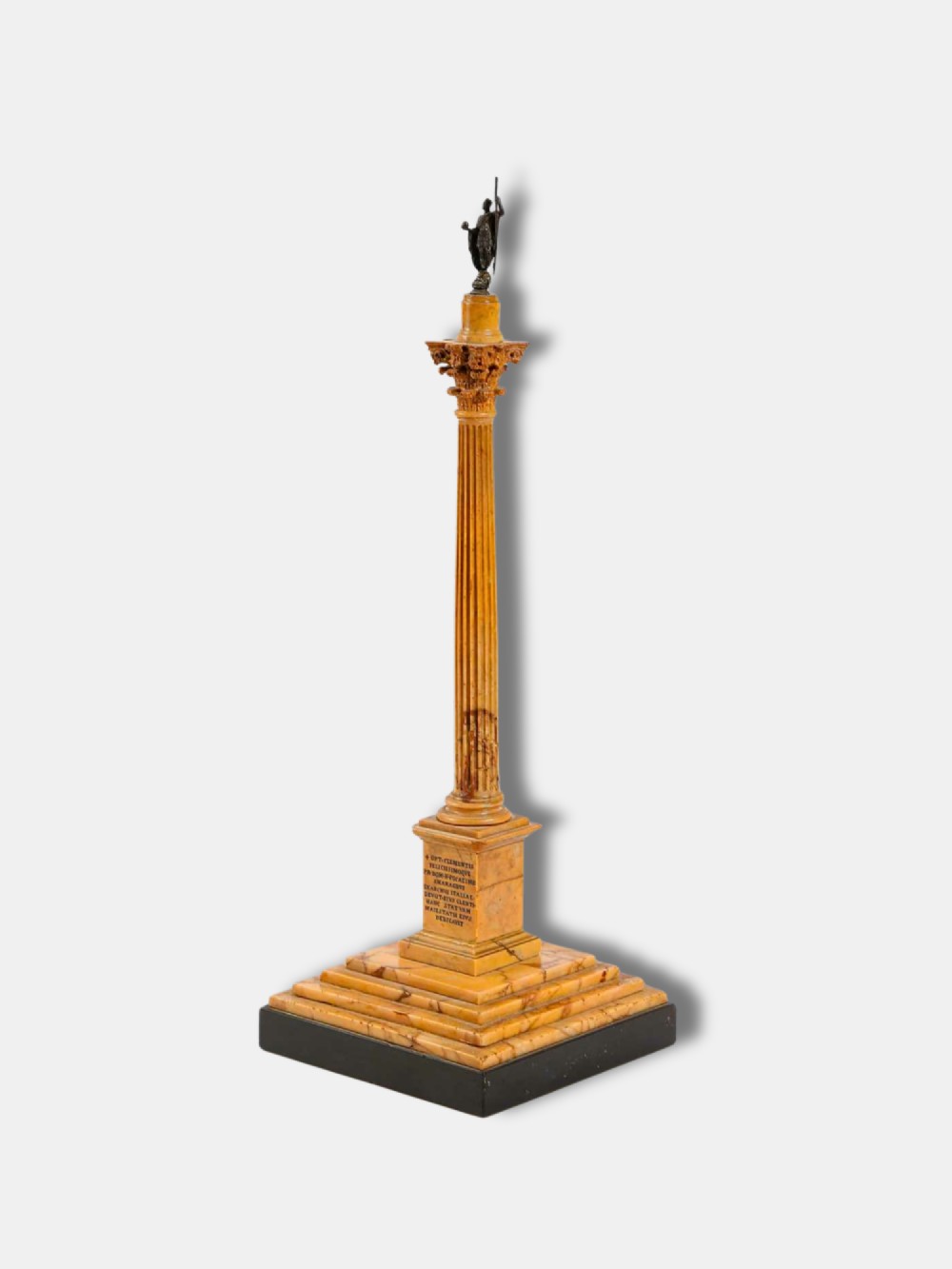 A detailed miniature architectural model of the Column of Phocas carved from yellow Giallo Antico marble with a small bronze figure atop, set upon a stepped square base.