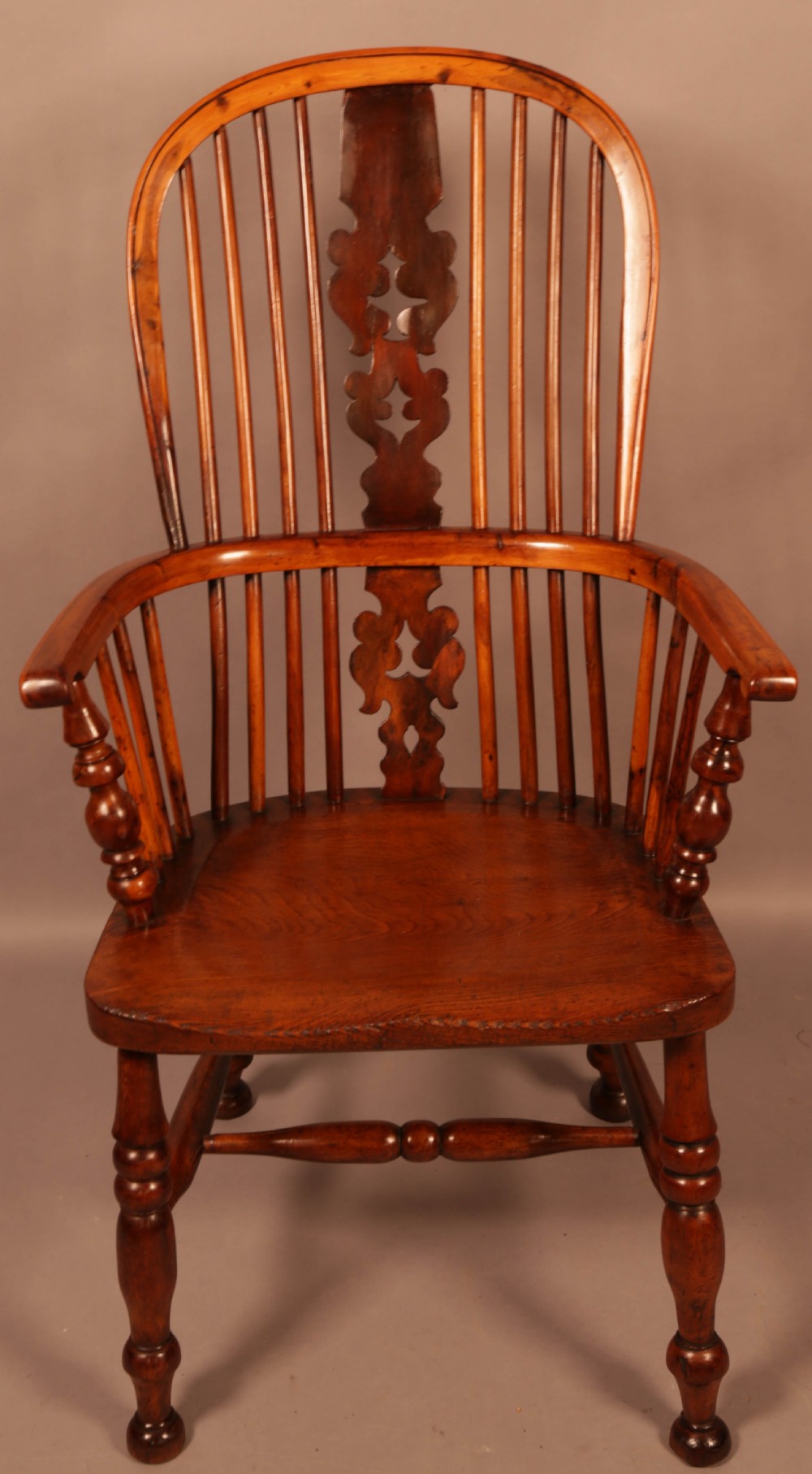A mid-19th century high-back yew wood Windsor armchair featuring a pierced central splat, steam-bent armrests, shaped seat, and turned legs. View II