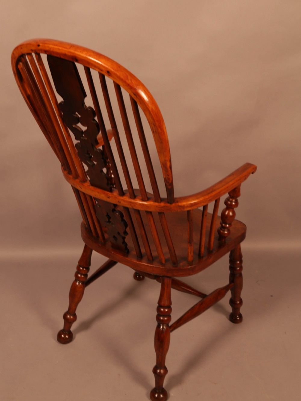A mid-19th century high-back yew wood Windsor armchair featuring a pierced central splat, steam-bent armrests, shaped seat, and turned legs. View III