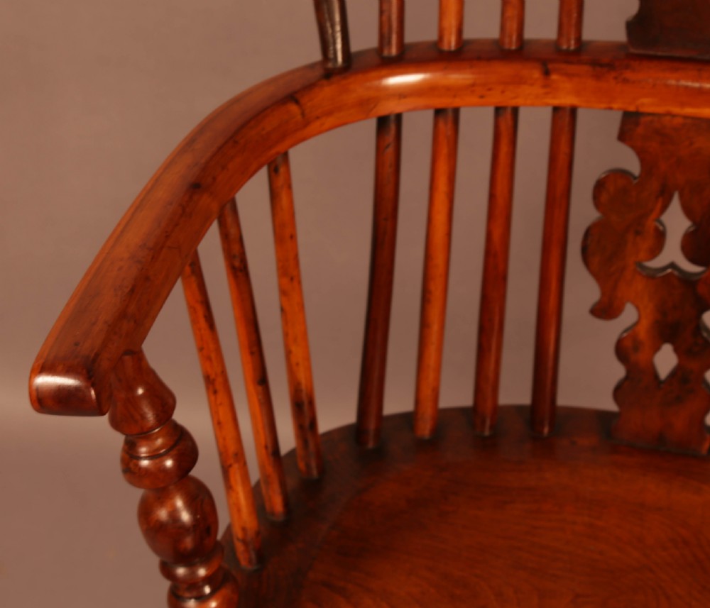 A mid-19th century high-back yew wood Windsor armchair featuring a pierced central splat, steam-bent armrests, shaped seat, and turned legs. View V