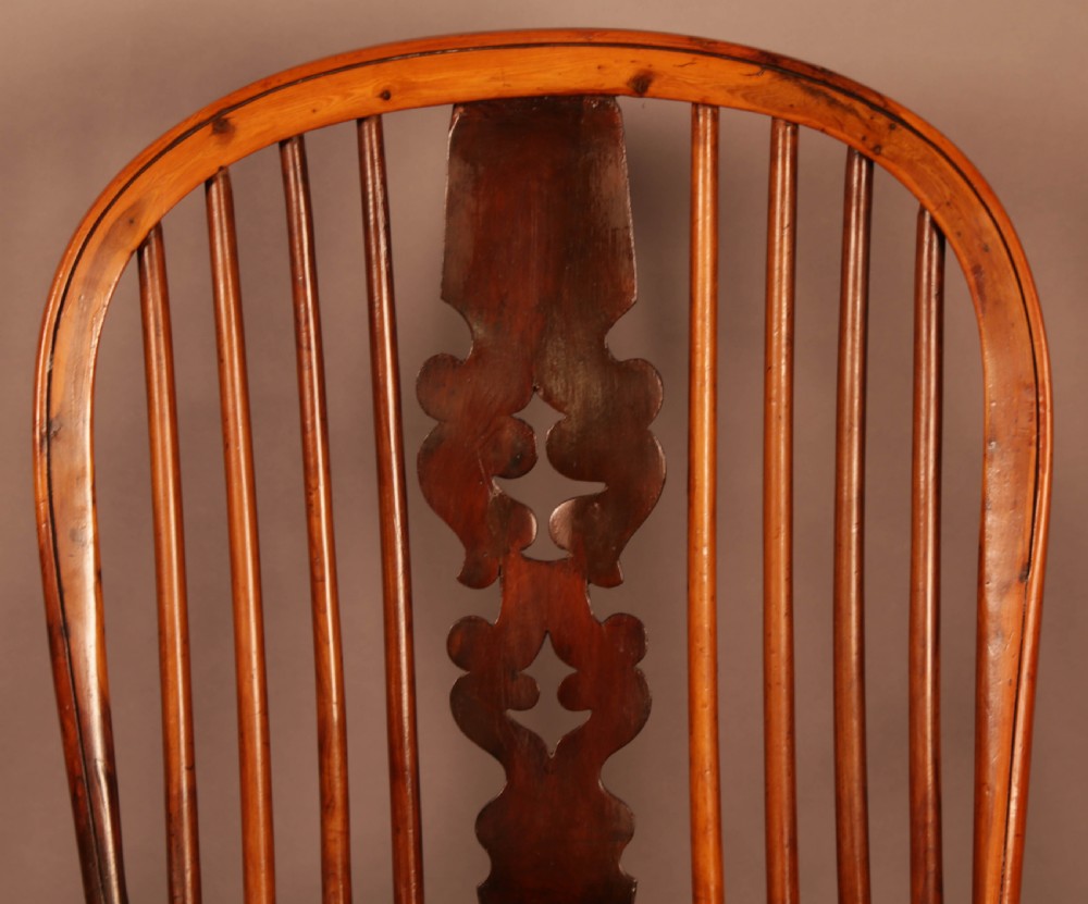 A mid-19th century high-back yew wood Windsor armchair featuring a pierced central splat, steam-bent armrests, shaped seat, and turned legs. View VI
