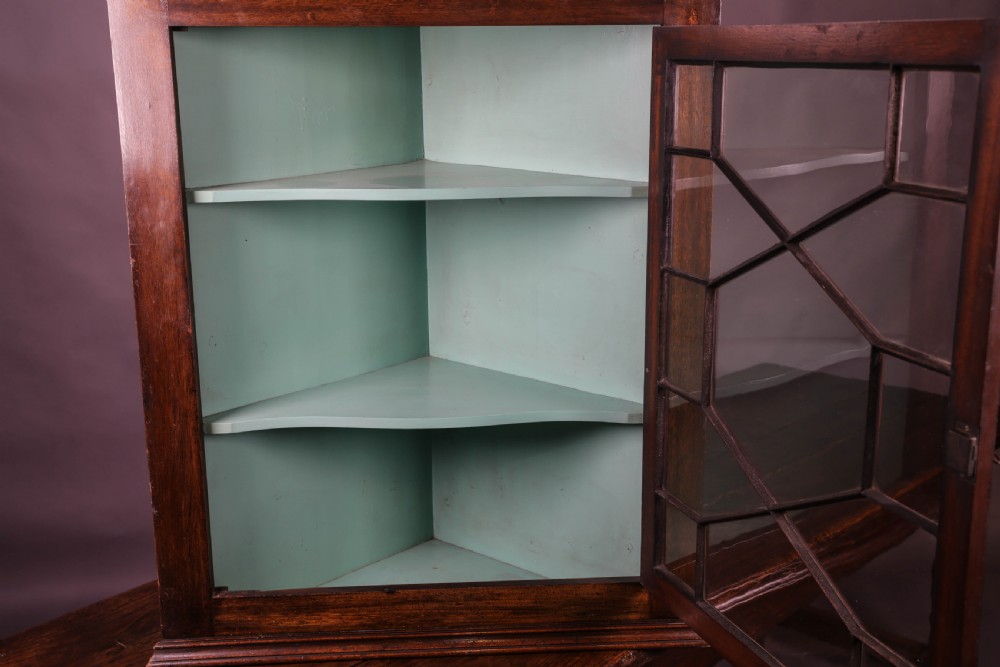 A Georgian mahogany corner cupboard featuring an astragal glazed door, dentil moulding along the cornice, and a painted green interior with three shelves. View IV