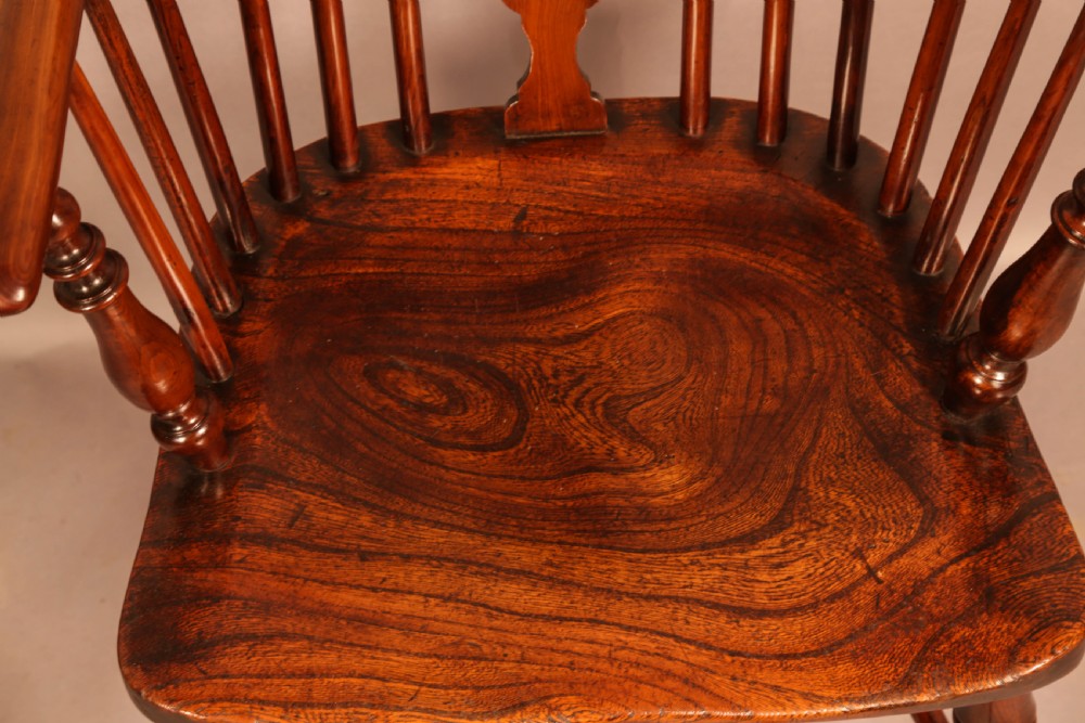 A traditional yew wood low-back Windsor armchair featuring a curved bow armrest, spindle back with central pierced splat, shaped solid seat, and turned legs with a crinoline stretcher. View III