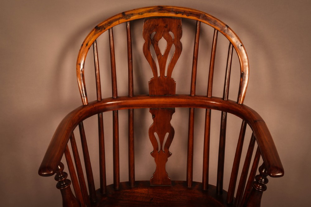 A traditional yew wood low-back Windsor armchair featuring a curved bow armrest, spindle back with central pierced splat, shaped solid seat, and turned legs with a crinoline stretcher. View VI