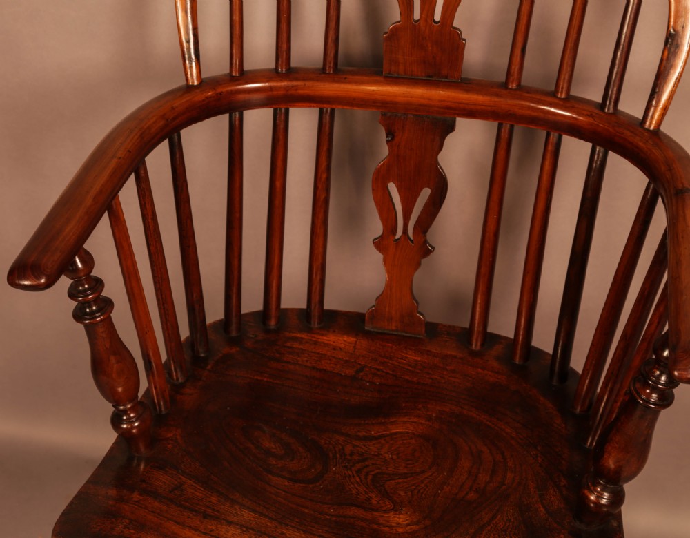 A traditional yew wood low-back Windsor armchair featuring a curved bow armrest, spindle back with central pierced splat, shaped solid seat, and turned legs with a crinoline stretcher. View VII