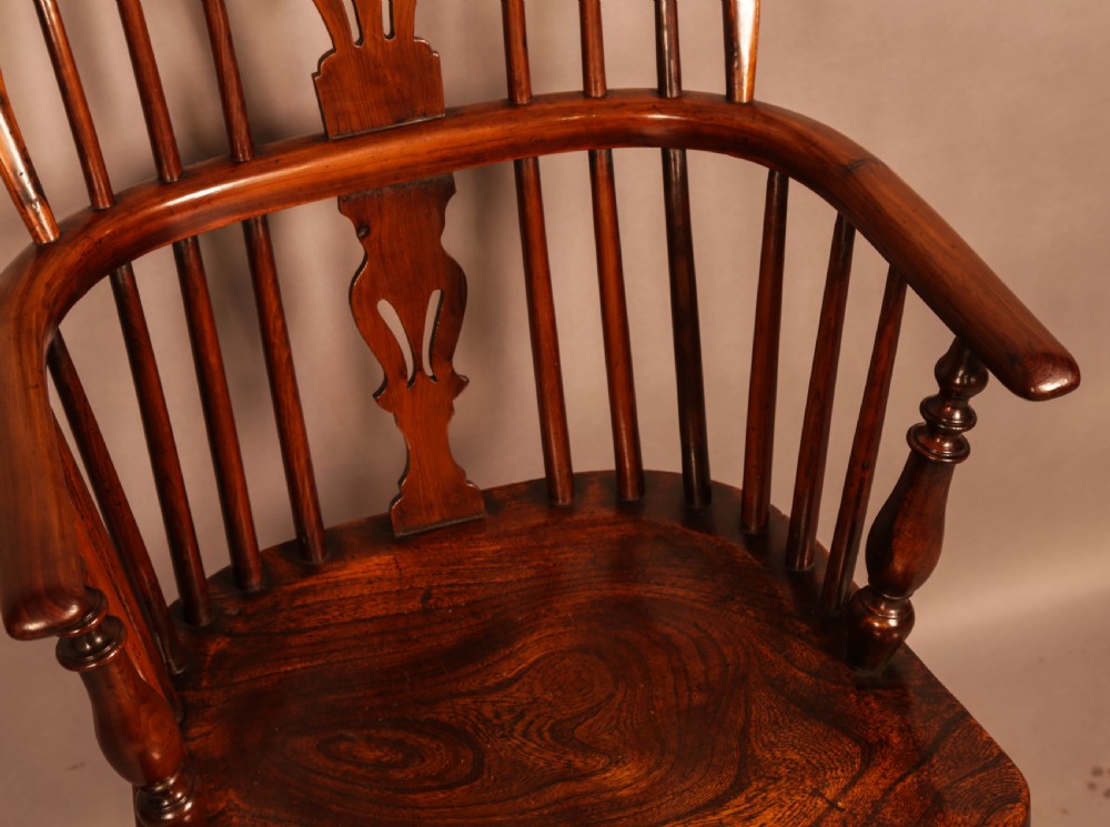 A traditional yew wood low-back Windsor armchair featuring a curved bow armrest, spindle back with central pierced splat, shaped solid seat, and turned legs with a crinoline stretcher. View VIII