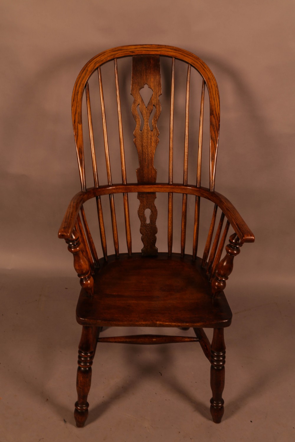 An antique high-back Windsor armchair crafted from ash and elm timber with turned legs and a pierced back splat. View III