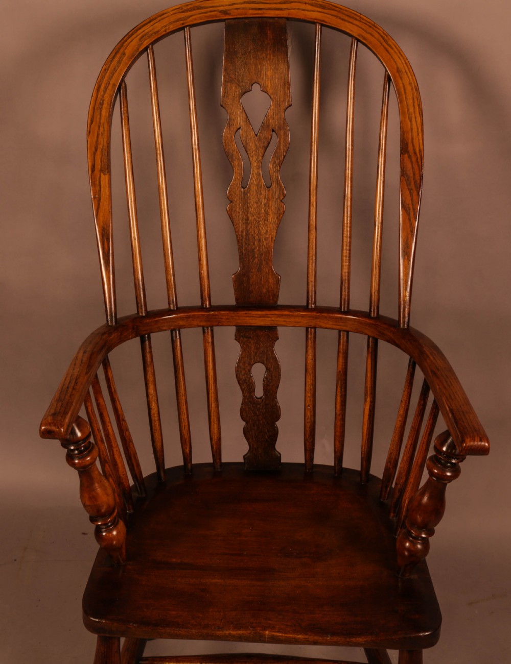 An antique high-back Windsor armchair crafted from ash and elm timber with turned legs and a pierced back splat. View IV