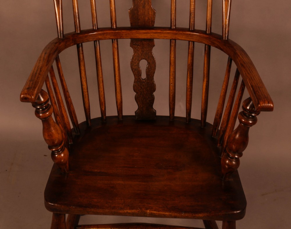 An antique high-back Windsor armchair crafted from ash and elm timber with turned legs and a pierced back splat. View V