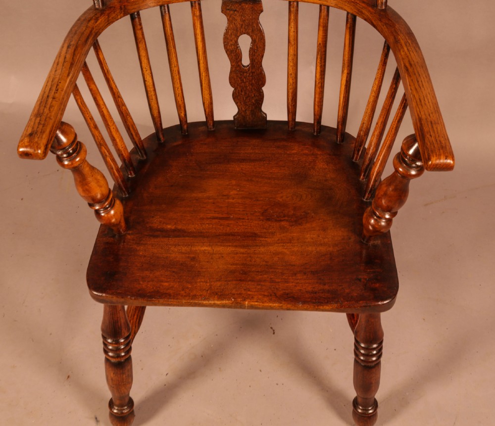 An antique high-back Windsor armchair crafted from ash and elm timber with turned legs and a pierced back splat. View VI