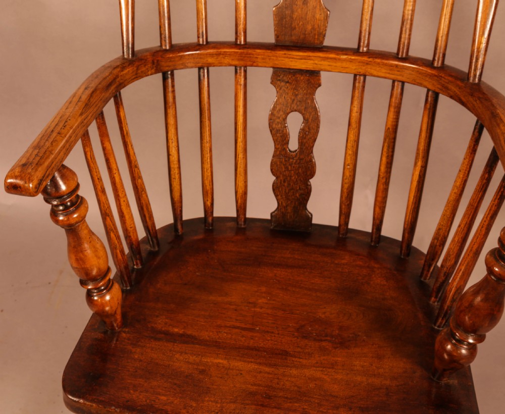 An antique high-back Windsor armchair crafted from ash and elm timber with turned legs and a pierced back splat. View VII