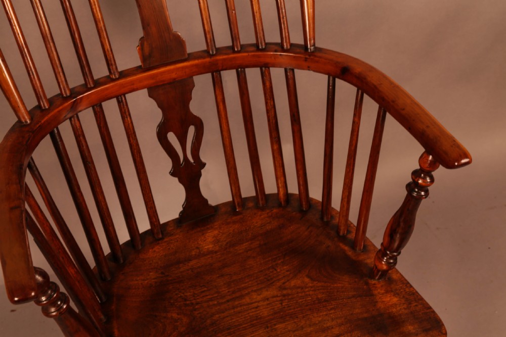 A high-backed wooden Windsor armchair featuring a pierced splat, slender spindles, and turned legs joined by an H-stretcher. View VII