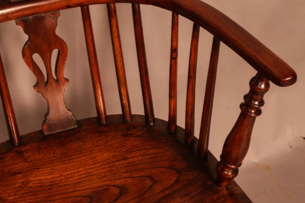 A yew wood low-back Windsor armchair featuring a curved top rail, pierced back splat, spindled arms, shaped solid seat, turned legs, and a crinoline stretcher. View VIII