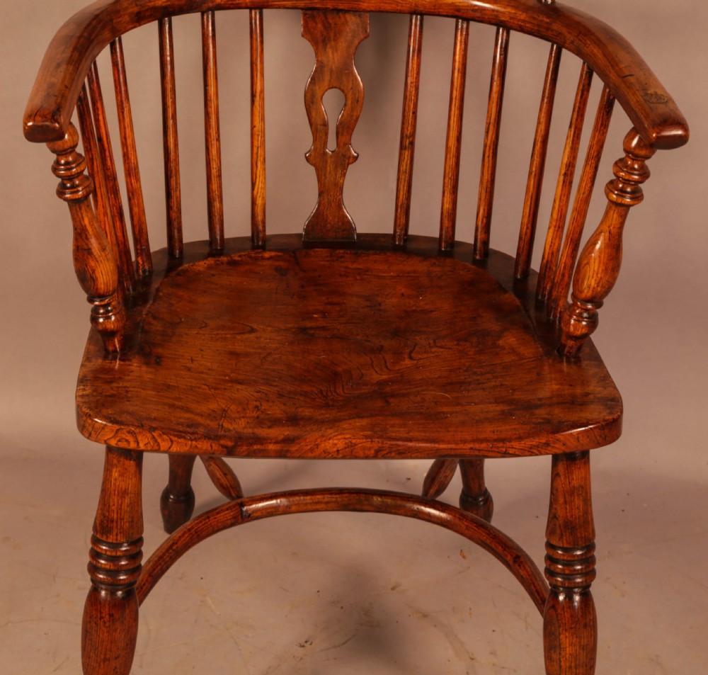 A traditional ash and elm low-back Windsor armchair with a shaped saddle seat, turned legs, and a steam-bent back hoop. View V