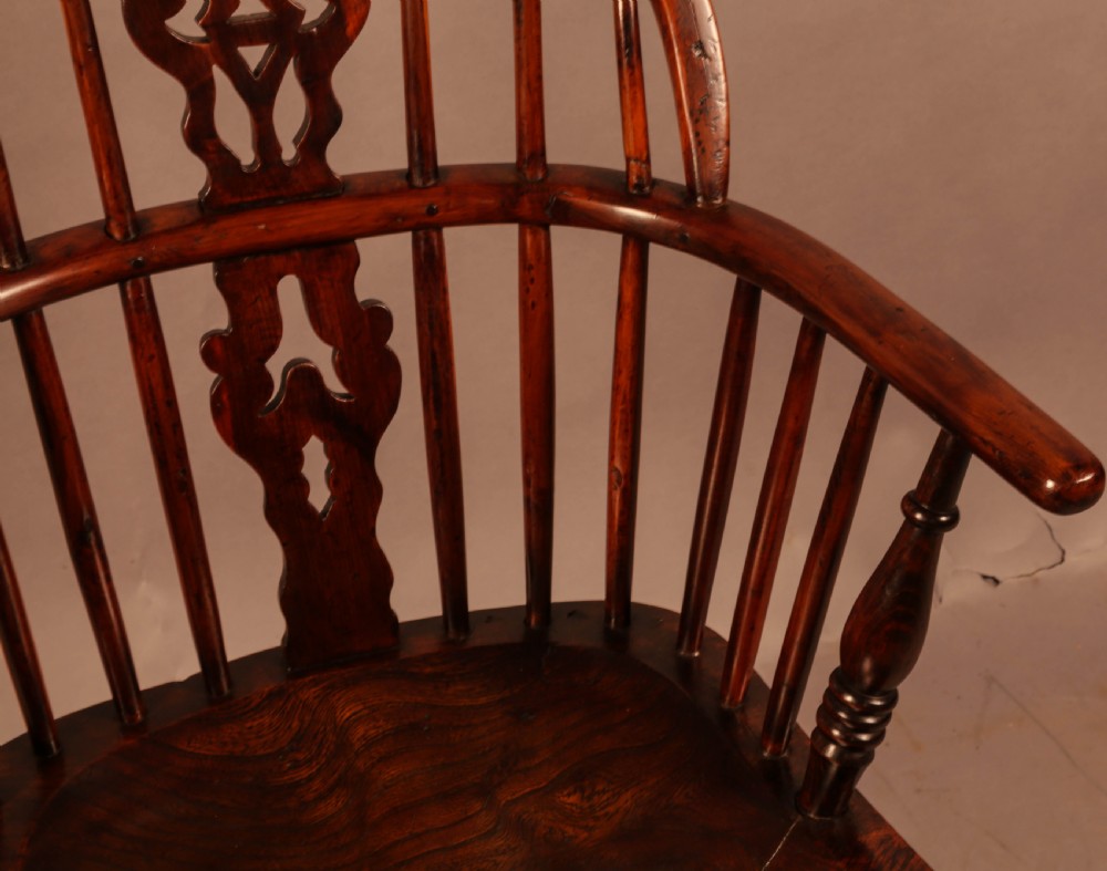 A nineteenth-century yew wood Windsor armchair featuring a curved hoop back, pierced central splat, turned arm supports, shaped saddle seat, and turned legs with a crinoline stretcher. View VIII